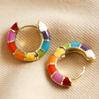 Pair of Rainbow Geometric Enamel Hoop Earrings in Gold on fabric background. One earring closed one open