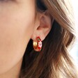 Shot of Model Wearing Red Floral Enamel Hoop Earrings in Gold