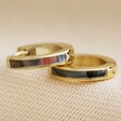 Shell Black Resin Infill Huggie Hoop Earrings in Gold on Beige Fabric