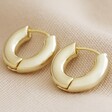 Small Chunky Huggie Hoop Earrings in Gold on Beige Fabric