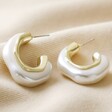 White Molten Pearlescent Hoop Earrings in Gold on Beige Fabric