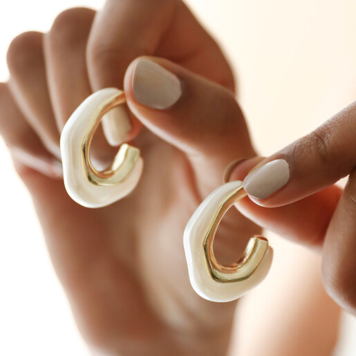 Model Holding White Molten Pearlescent Hoop Earrings in Gold