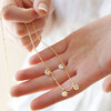 Model Holding Beaded Daisy Satellite Chain Necklace in Gold