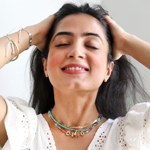 Smiling Model Wearing Millefiori Bead Ciao Necklace Layered with More Necklaces