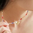model wearing personalised rainbow beads and freshwater pearl necklace and pulling it away from their neck