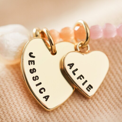 close up of large and small gold hand stamped heart charms