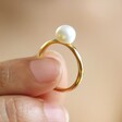 Model Holding Pearl Ring in Hammered Gold