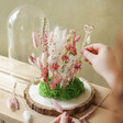 model arranging flowers in Blooming Lovely Dried Flower Cloche Kit