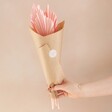 Model Holding Wrapped Bunch of Four Dried Palm Spears in Pink