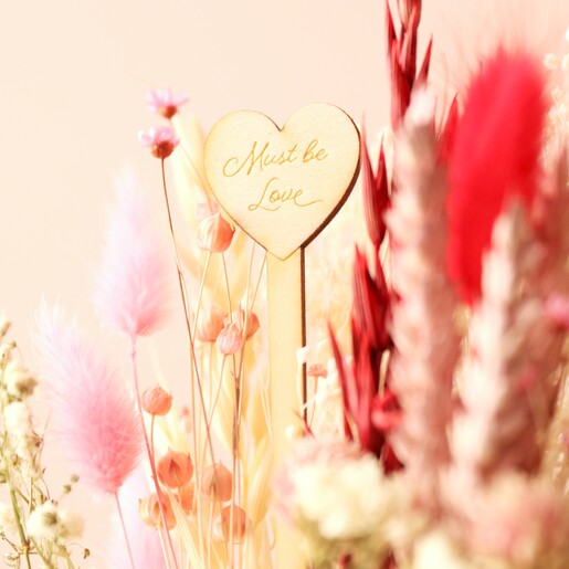 Close Up of Top of Wooden 'Must Be Love' Stick from Valentine's Dried Flower Posy with Engraved Stick