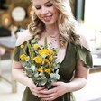 Eucalyptus and Yellow Dried Flower Wedding Posy Held by Model