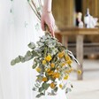 Model Holds Eucalyptus and Yellow Dried Flower Wedding Bouquet