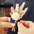 Model Holding Vintage Pink Dried Flower Buttonhole Against Navy Lapel