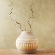 wooden plant inside Large Round Hand-Painted Vase in Grey sat on wooden table