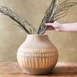 model arranging plants in Large Round Hand-Painted Vase in Grey