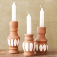 3 Terracotta Candlesticks on Wood Surface
