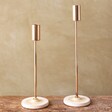 Small and Large Gold Candlestick Holders with Glazed Bases on Wooden Table