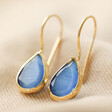Blue Teardrop Drop Earrings in Gold on Fabric 