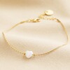 Pearl Heart Charm Bracelet in Gold Full Length on Beige Material