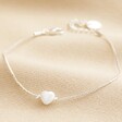 Pearl Heart Charm Bracelet in Silver Full Length on Beige Coloured Material