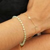 Model Wearing Set of 2 Leaf Chain and Green Beaded Bracelets in Gold