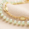 Close Up of Set of 2 Leaf Chain and Green Beaded Bracelets in Gold