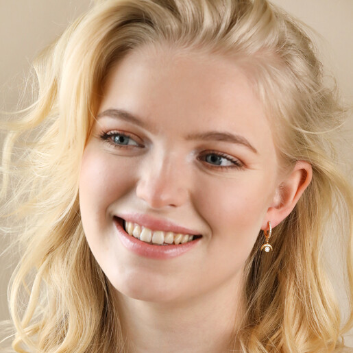 Model Smiling Wearing Crystal Crescent Moon Huggie Earrings in Gold