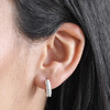 Close Up of Crystal and Pearl Huggie Hoop Earrings in Silver on Dark Haired Model