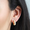 Close up of model wearing Moon Phase Enamel Huggie Hoop Earrings in Gold