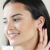 Model smiling wearing Moon Phase Enamel Huggie Hoop Earrings in Gold with hand behind ear