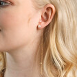 Close Up of Model Wearing Pearl and Chain Drop Stud Earrings in Gold
