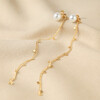 Pearl and Chain Drop Stud Earrings in Gold on Beige Coloured Fabric