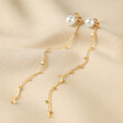Pearl and Chain Drop Stud Earrings in Gold on Beige Coloured Fabric