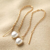 Thread Through Pearl Chain Earrings in Gold on Beige Coloured Fabric