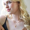 Model Wearing Feminine Figure Pendant Necklace in Gold Stacked with Other Necklaces