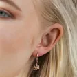 Close Up of Model Wearing Hanging Sloth Huggie Hoop Earrings in Rose Gold