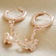 Hanging Sloth Huggie Hoop Earrings in Rose Gold on Beige Coloured Material