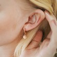Close Up of Model Wearing Daisy Earring From Mismatched Daisy and Bee Huggie Hoop Earrings in Rose Gold
