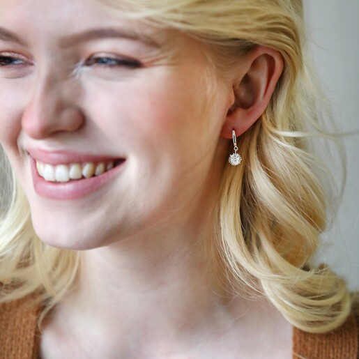Model Wearing Daisy Charm Mismatched Daisy and Bee Huggie Hoop Earrings in Silver