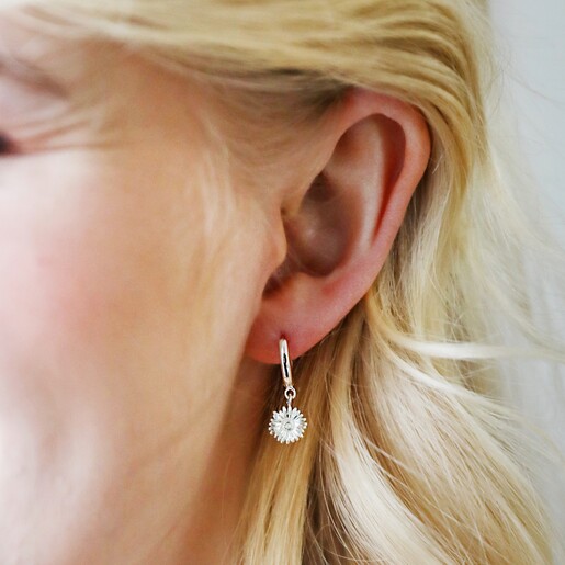 Model Wearing Daisy Charm Mismatched Daisy and Bee Huggie Hoop Earrings in Silver