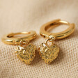 Molten Heart Huggie Hoop Earrings in Gold on Beige Fabric