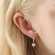 Close Up of Molten Heart Huggie Hoop Earrings in Silver on Model