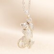 Close up of Cat Pendant Necklace in Silver dangling on neutral coloured fabric