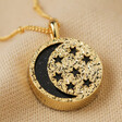 Close Up of Celestial Semi-Precious Stone Pendant Necklace in Gold on Beige Fabric