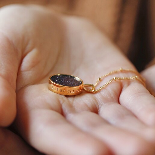 Model Holding Celestial Semi-Precious Stone Pendant Necklace in Gold in Palm