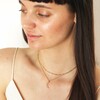 Model looking to side wearing Colourful Crystal Crescent Moon Hammered Pendant Necklace in Gold layered with other necklace