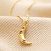 Close up of pendant on Colourful Crystal Crescent Moon Hammered Pendant Necklace in Gold on beige background
