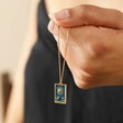 Model Holding Enamel Blue Moon Tarot Card Pendant Necklace in Gold in Hand with Pendant Hanging