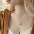 Model Looking to Side Wearing Hanging Sloth Pendant Necklace in Rose Gold