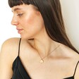 Model looking to side wearing Multicoloured Crystal Daisy Disc Pendant Necklace in Gold